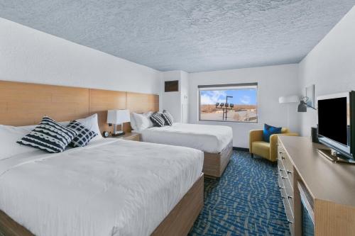 una habitación de hotel con dos camas y un televisor de pantalla plana en Mulberry, a Wyndham Hotel, en Vicksburg