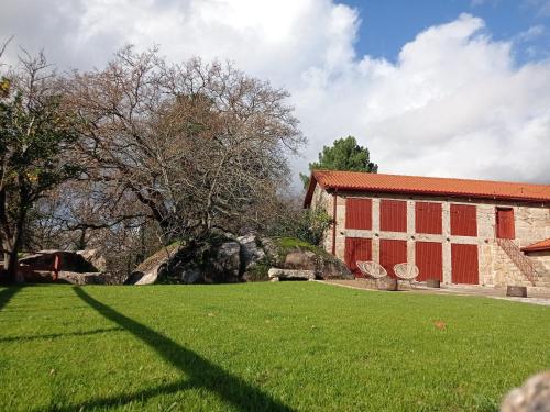 a building with a grassy yard next to a building at Quinta Pousada de Fora Wines & Tourism in Guimarães