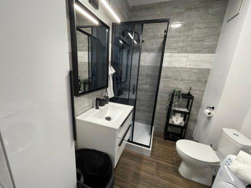 a bathroom with a toilet and a sink and a shower at Modern Box Apartment in Gdynia