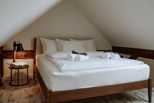 ein großes weißes Bett mit vier Kissen darauf in der Unterkunft Apartments of Hana Hegerová in Hurbanovo