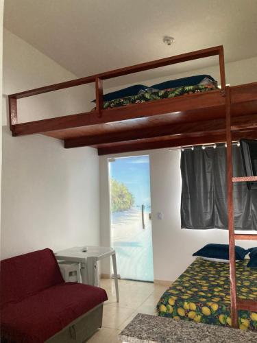 ein Schlafzimmer mit einem Etagenbett und einem Sofa in der Unterkunft Aconchego Meu in Cabo Frio