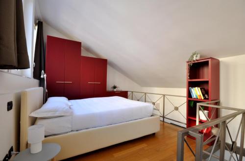 a bedroom with a white bed and red cabinets at Loft ristrutturato vicino M4 Argonne - San Benigno in Milan