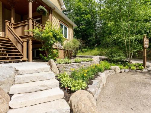 a yard with a stone pathway leading to a house at Les Dames du Lac in Mont-Tremblant