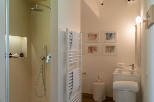 a bathroom with a shower and a toilet and a sink at CasaVostra - Ambience Suites in Ostra Vetere