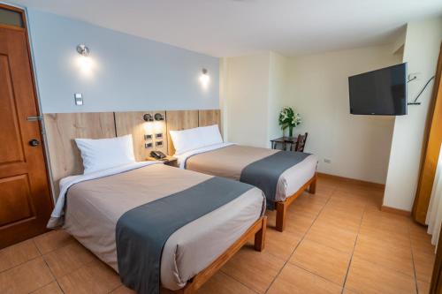 Habitación de hotel con 2 camas y TV de pantalla plana. en Casa Villa Arequipa en Arequipa