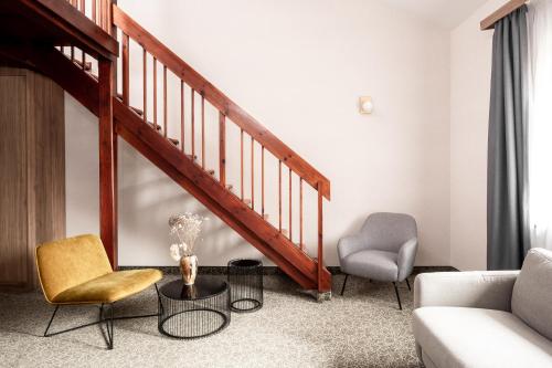 a living room with a staircase and two chairs at Dwór w Tomaszowicach in Modlnica