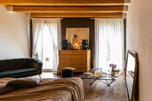 a living room with a green couch and a dresser at CasaVostra - Ambience Suites in Ostra Vetere