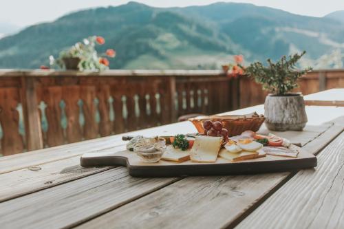 una bandeja de queso y carne en una mesa de madera en Appartement Diana, en Sankt Veit im Pongau