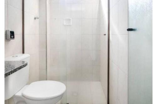 a white bathroom with a toilet and a shower at Hotel Park Leste, São Paulo in Sao Paulo