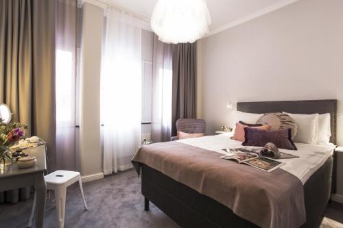 a bedroom with a large bed and a chandelier at Best Western Kom Hotel Stockholm in Stockholm