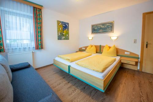 a bedroom with a bed with yellow sheets and yellow pillows at Apartment Bacher in Wald im Pinzgau