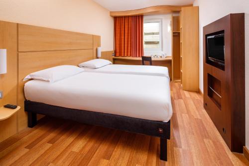 a hotel room with a large bed and a television at ibis Bristol Centre in Bristol