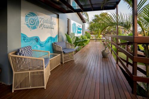 eine Terrasse mit Stühlen und ein Schild an der Wand in der Unterkunft Pousada Tartarugas Marinhas in Fernando de Noronha