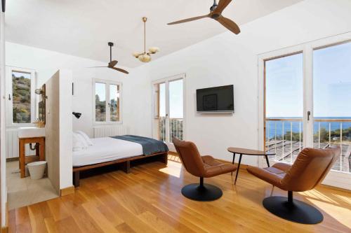 a bedroom with a bed and two chairs and a tv at Villa Vito in Hvar