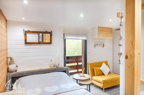 - une chambre avec un lit et une chaise jaune dans l'établissement Gîte des 3 lutins, à Eschbach-au-Val