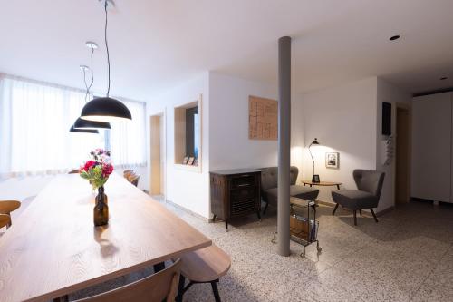 Una sala de estar con una mesa con un jarrón de flores encima. en DOMUS FABER, en Merano