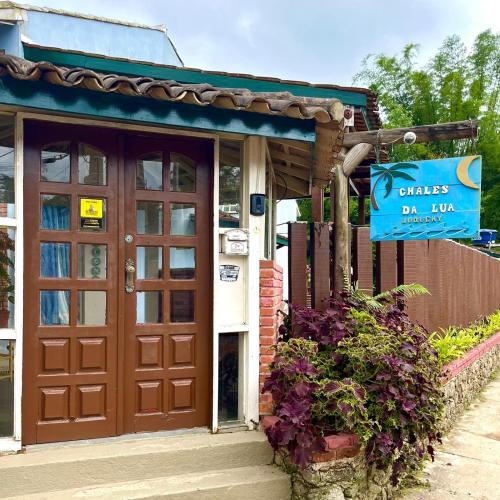 a building with a brown door and a sign on it at Chales da Lua Juquehy in Juquei
