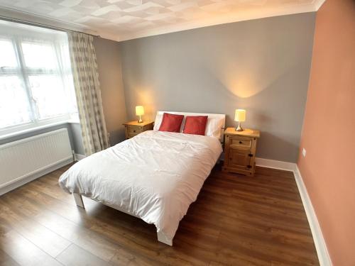 Un dormitorio con una cama con almohadas rojas. en Richmond HOUSE, en Slough