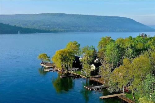 a view of a lake with trees and a house at Lakeside Condo with plenty of amenities close to Bristol Mountain - permit - 2024-0018 in Canandaigua