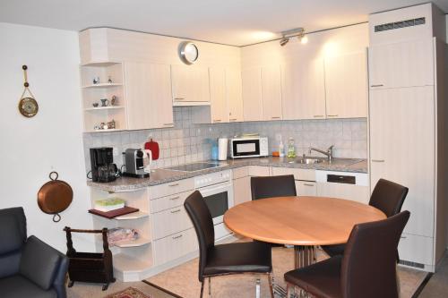 uma cozinha com uma mesa e cadeiras numa cozinha em Sotmirana 53 (316 Sh) em Lenzerheide