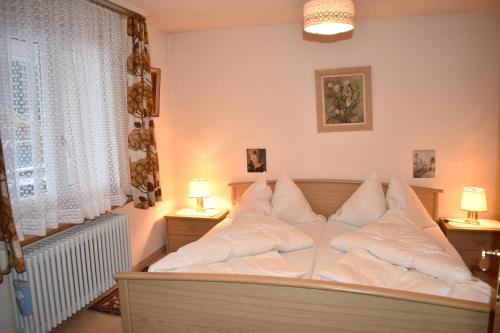 a bedroom with a bed with white pillows at Sotmirana 53 (316 Sh) in Lenzerheide