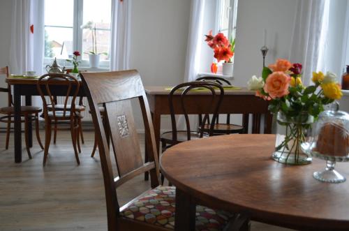 a dining room with tables and chairs and flowers in a vase at Hotel "Cafe Verkehrt" - Wellcome Motorbiker, Berufsleute und Reisende im Schwarzwald in Oberhof