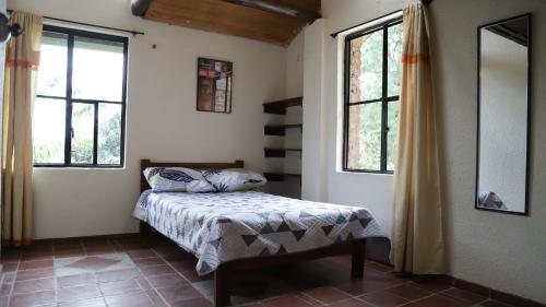 - une chambre avec un lit et 2 fenêtres dans l'établissement Arte sin Fronteras Hostel, à Paipa