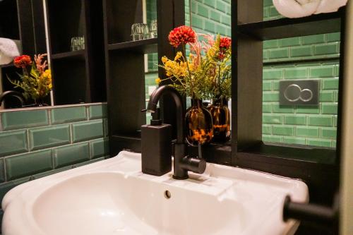 a bathroom sink with a faucet and flowers on it at Villa la Vida in Tilburg
