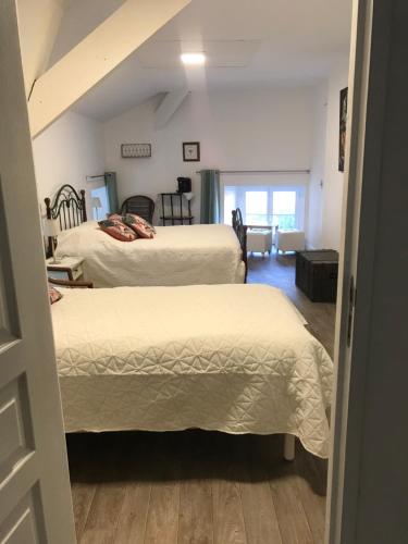 a bedroom with two beds and a hallway at MOULIN DE L'ABBESSE in Thouars