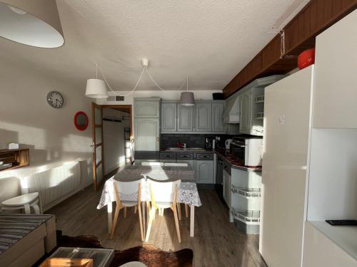 a kitchen with a table and a dining room at Appartement avec Terrasse - Soleil des Alpes - Orcières-Merlette 1850 in Orcières