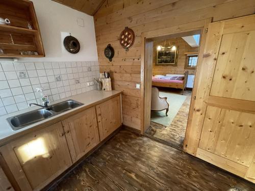cocina con fregadero y puerta a un dormitorio en Geigerhaus 500 Jahre - Appt C, en Stuhlfelden