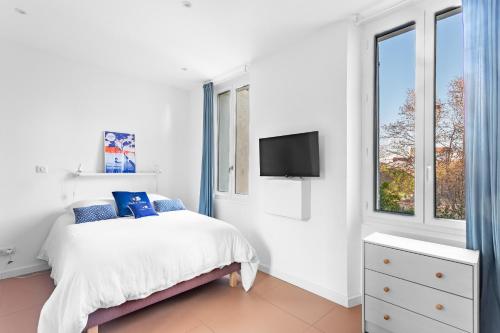 um quarto branco com uma cama e uma televisão em Agreeable studio with AC in le Mourillon - Dodo et Tartine em Toulon