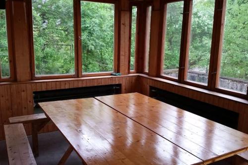 a wooden table in a room with windows at Rony Villa - In the middle of nature in Przesieka