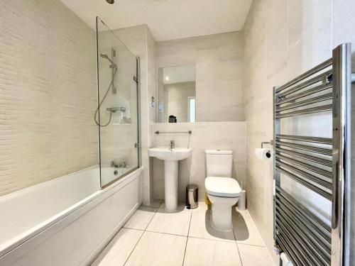 uma casa de banho com um WC, um lavatório e um chuveiro em Classy Campbell Park Apartment, Balcony & Free Parking em Milton Keynes