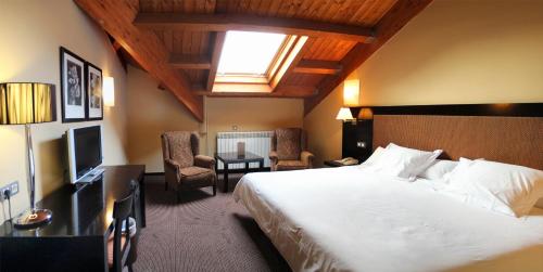 a hotel room with a large bed and a window at HG Alto Aragón in Formigal