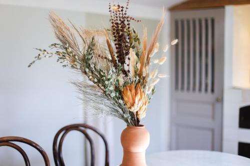 a vase with flowers in it sitting on a table at La Madone in Apt