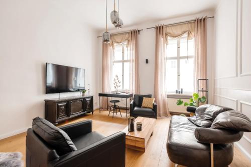 a living room with a couch and a tv at 90sqm 2BR Biz LOFT - 5min Central Station in Berlin