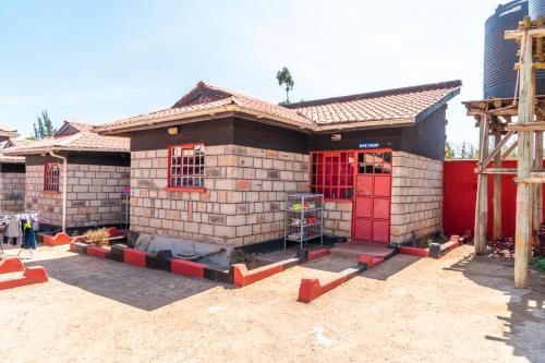 a small house with red doors on a street at RUN'IX ATHLETIC CENTER in Iten