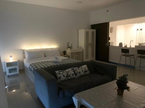 uma sala de estar com uma cama e um sofá em Warmest Homestay-Trefoil,Setia Alam 2pax em Shah Alam
