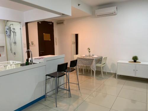 uma cozinha com um lavatório e uma mesa com cadeiras em Warmest Homestay-Trefoil,Setia Alam 2pax em Shah Alam