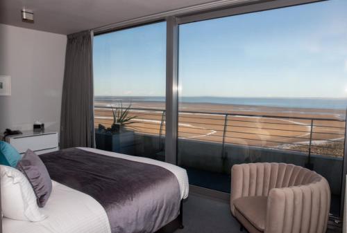 a bedroom with a bed and a balcony with a view at Midland Hotel in Morecambe