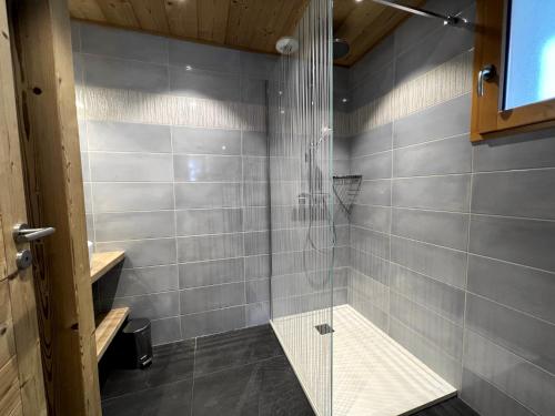une douche avec une porte vitrée dans une salle de bain dans l'établissement Pastorale - Très bel appartement 3 chambres, à La Clusaz