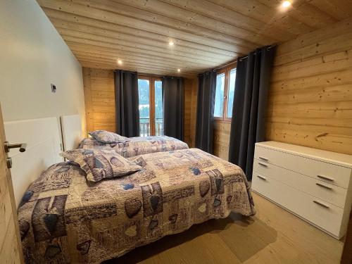 une chambre avec deux lits dans une cabane en rondins dans l'établissement Pastorale - Très bel appartement 3 chambres, à La Clusaz