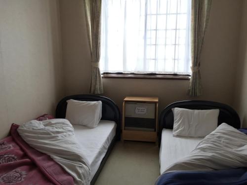 En eller flere senger på et rom på Resort Inn Daiju