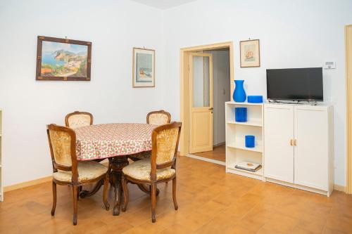 een eetkamer met een tafel, stoelen en een televisie bij 057 - Casa Portobello, Centrale a 50 metri dal mare in Sestri Levante