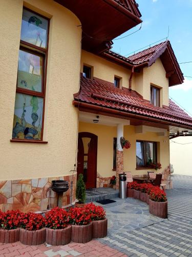 uma casa com flores vermelhas em frente em Willa Danielski em Niedzica