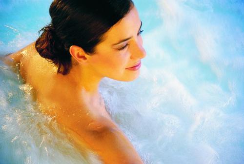 a woman sitting in a pool of water at Hotel Tschurtschenthaler in Dobbiaco