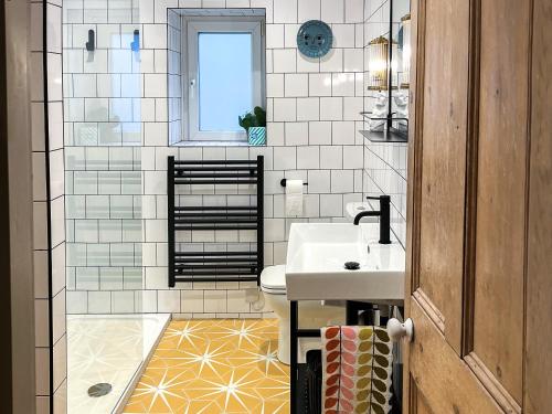 a bathroom with a sink and a toilet at Little Brook Cottage in Hebden