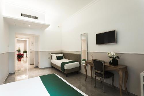 羅馬的住宿－梵蒂岡豪華賓館，酒店客房配有一张床、一张书桌和一台电视。