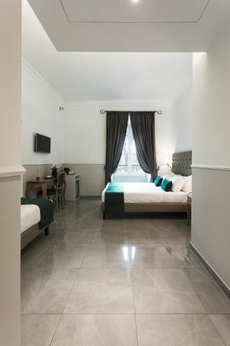 a bedroom with two beds and a table and a window at Vaticano Luxury Guest House in Rome